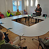 Die Äbtissin Ulrike Kempe spricht vor einer Gruppe von zehn Personen in einem Konferenzraum der Klosterkammer über das Wohnen im alter im Kloster Marienwerder.