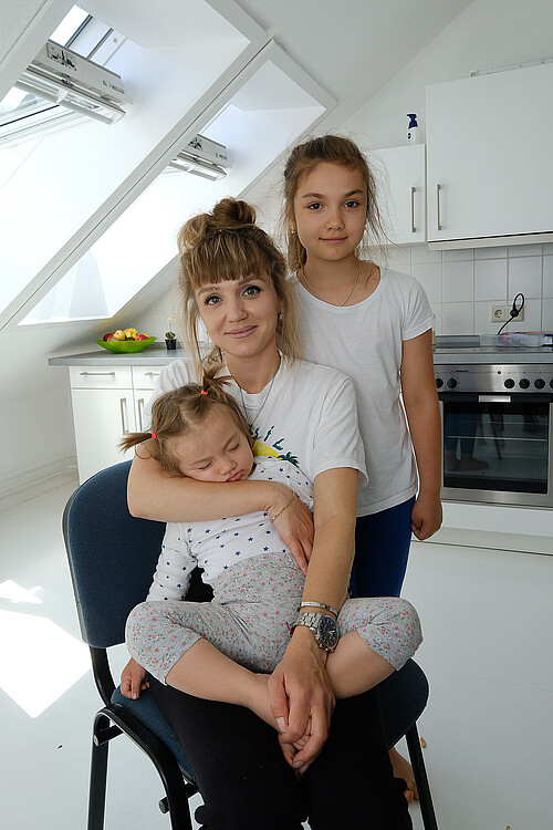Eine ukrainische Mutter sitz mit ihren zwei Töchtern in einer Wohnung der Klosterkammer.